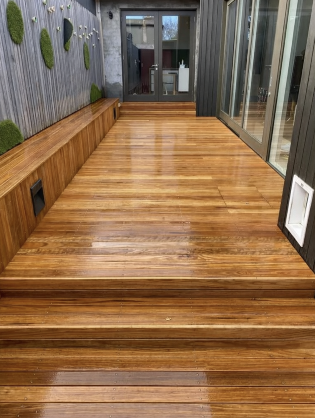 Same deck after restoration with rich stain and new boards