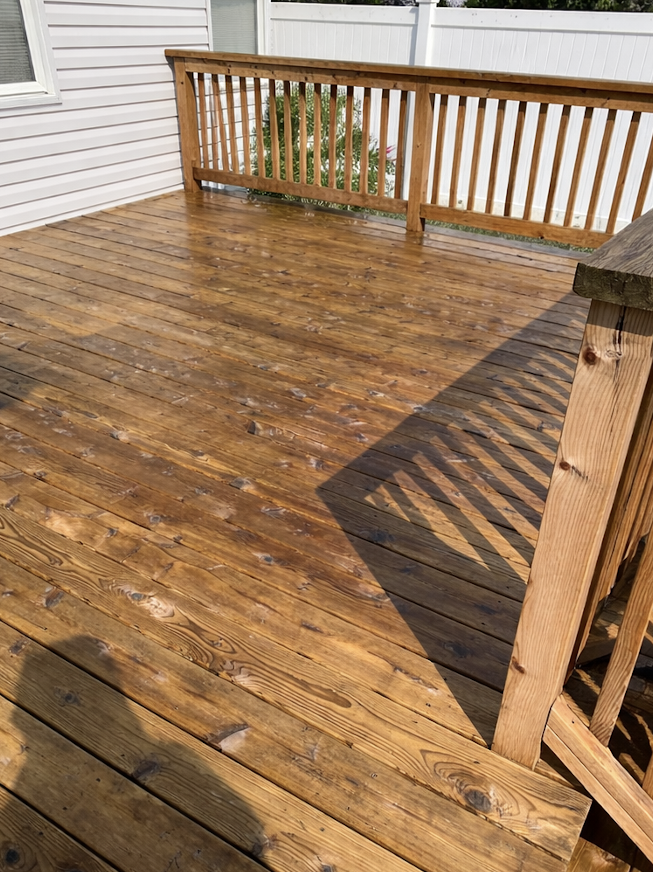 Deck after restoration with fresh stain and tightened railings