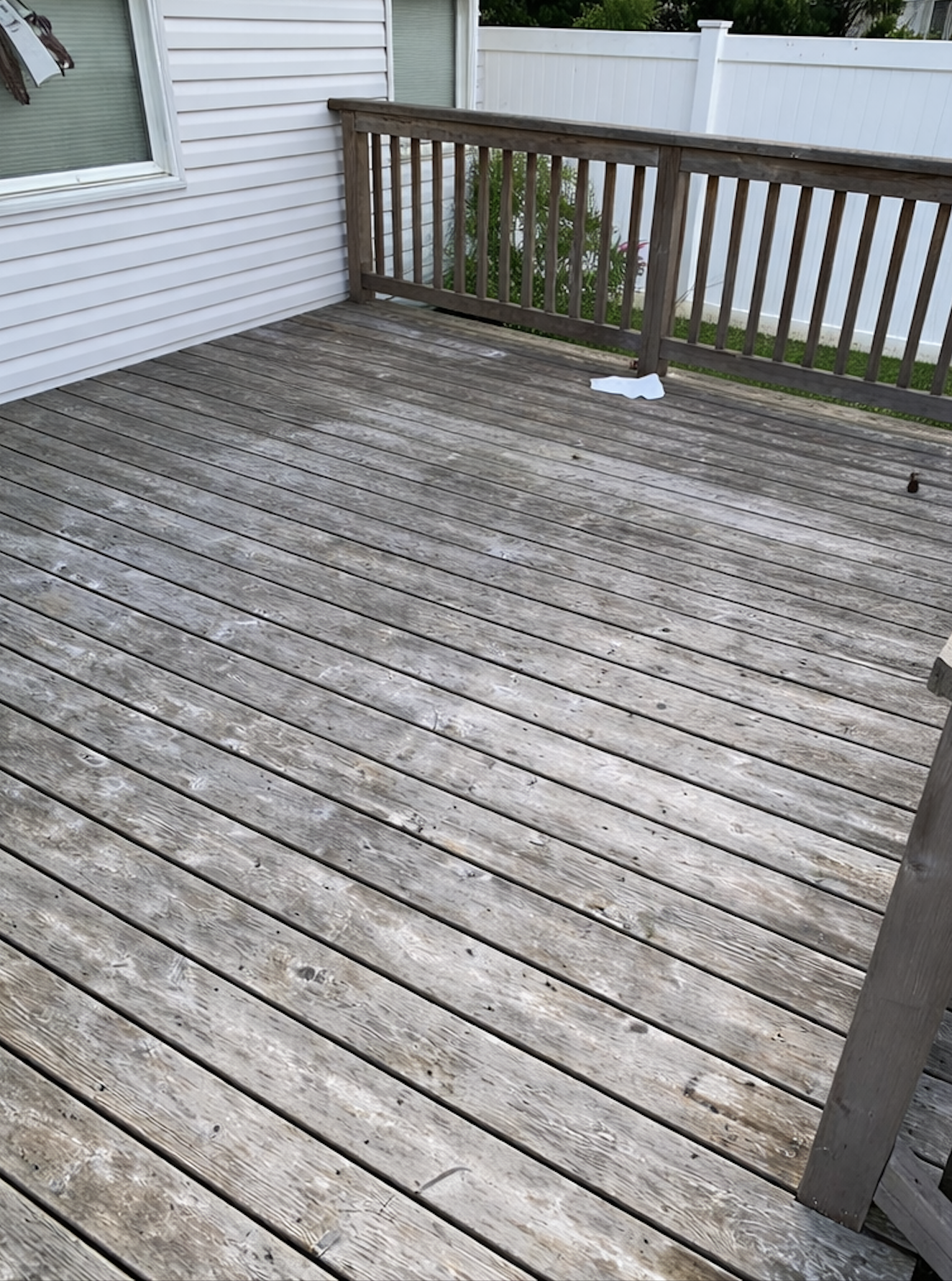 Weathered grey pressure treated deck before restoration